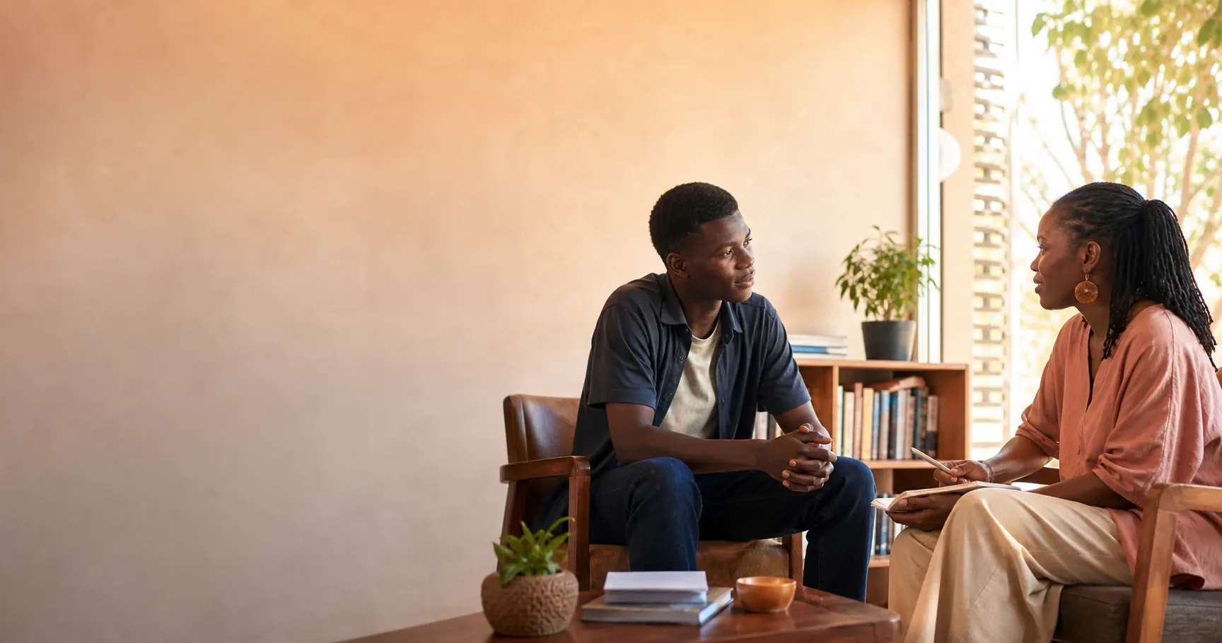 Two young Ghanaian adults in a calm educational conversation